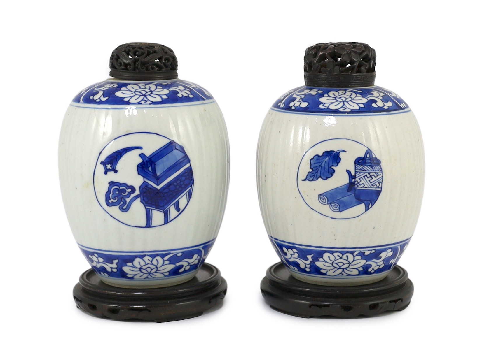 A pair of Chinese blue and white ribbed ovoid jars, Kangxi period, 13.4cm high, excluding wood stand and cover, one chipped with hairline crack
